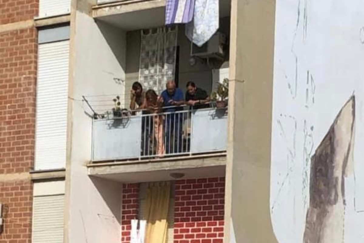 Famiglia affacciata dal balcone parla con la preside