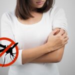 ragazza si gratta braccio, simbolo stop zanzara