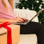 donna al pc con pacco e albero di Natale