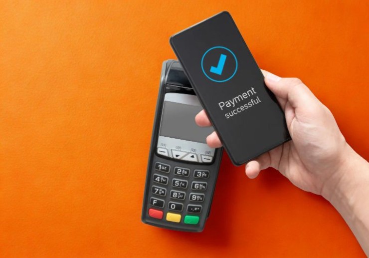 persona che paga mettendo il cellulare vicino al pos
