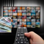 persona davanti alla tv con il telecomando in mano