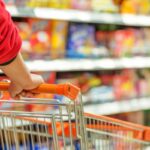 donna al supermercato che spinge il carrello