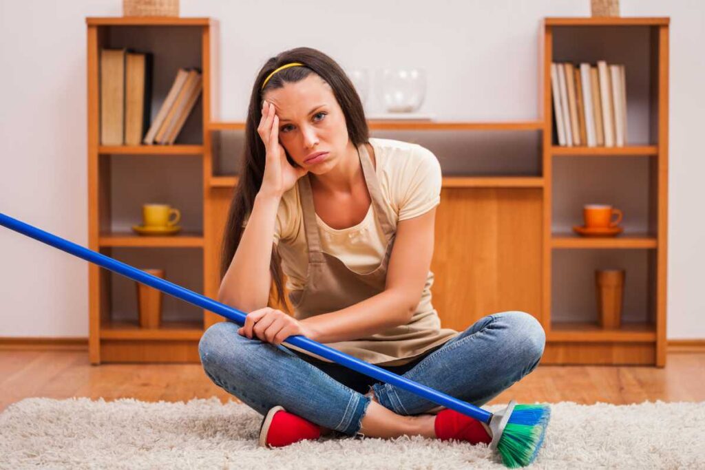 ragazza triste con scopa in mano