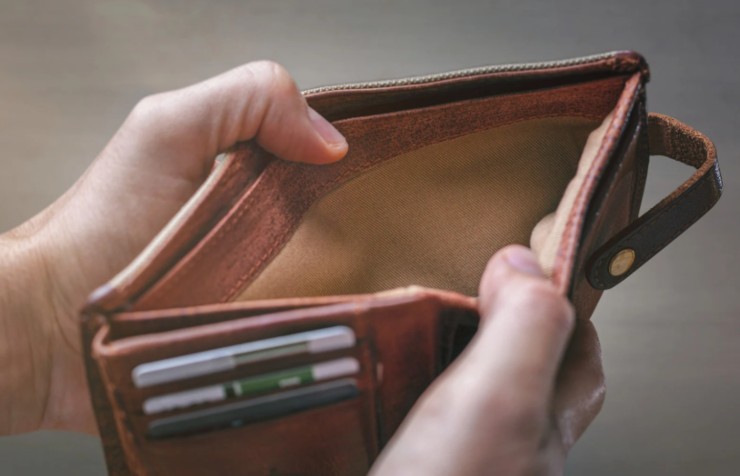 persona che tiene in mano un portafoglio vuoto