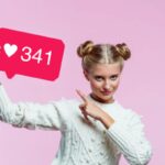 donna che indica un cartellone su cui è scritto un numero e disegnato un cuore