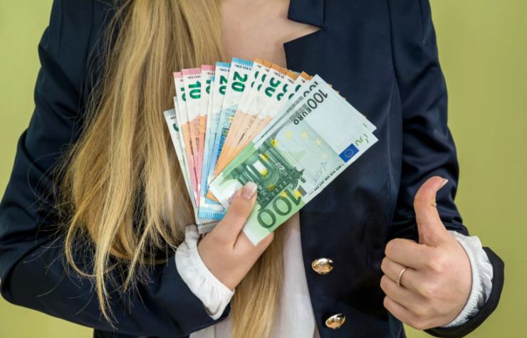 donna con in mano tante banconote di euro