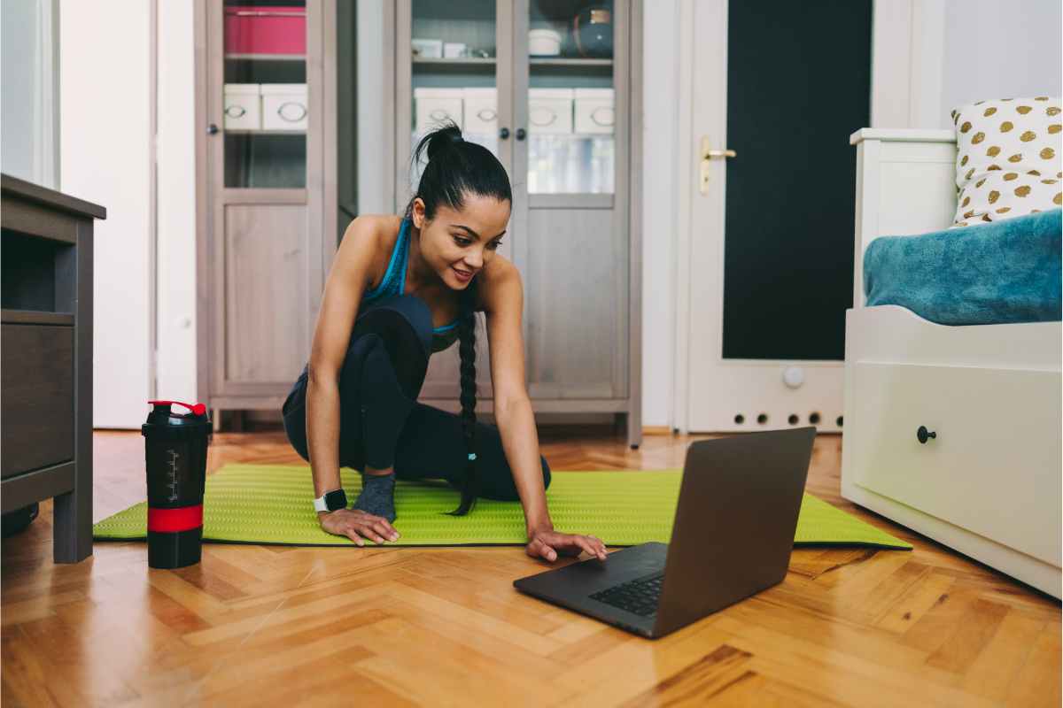 Ragazza che si allena sul pavimento di casa