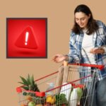 donna con il carrello della spesa pieno di cibo e simbolo del pericolo