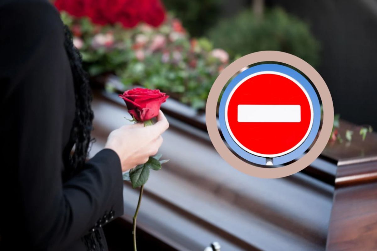 persona con in mano una rosa rossa accanto ad una bara