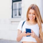 donna sorridente con il cellulare in mano