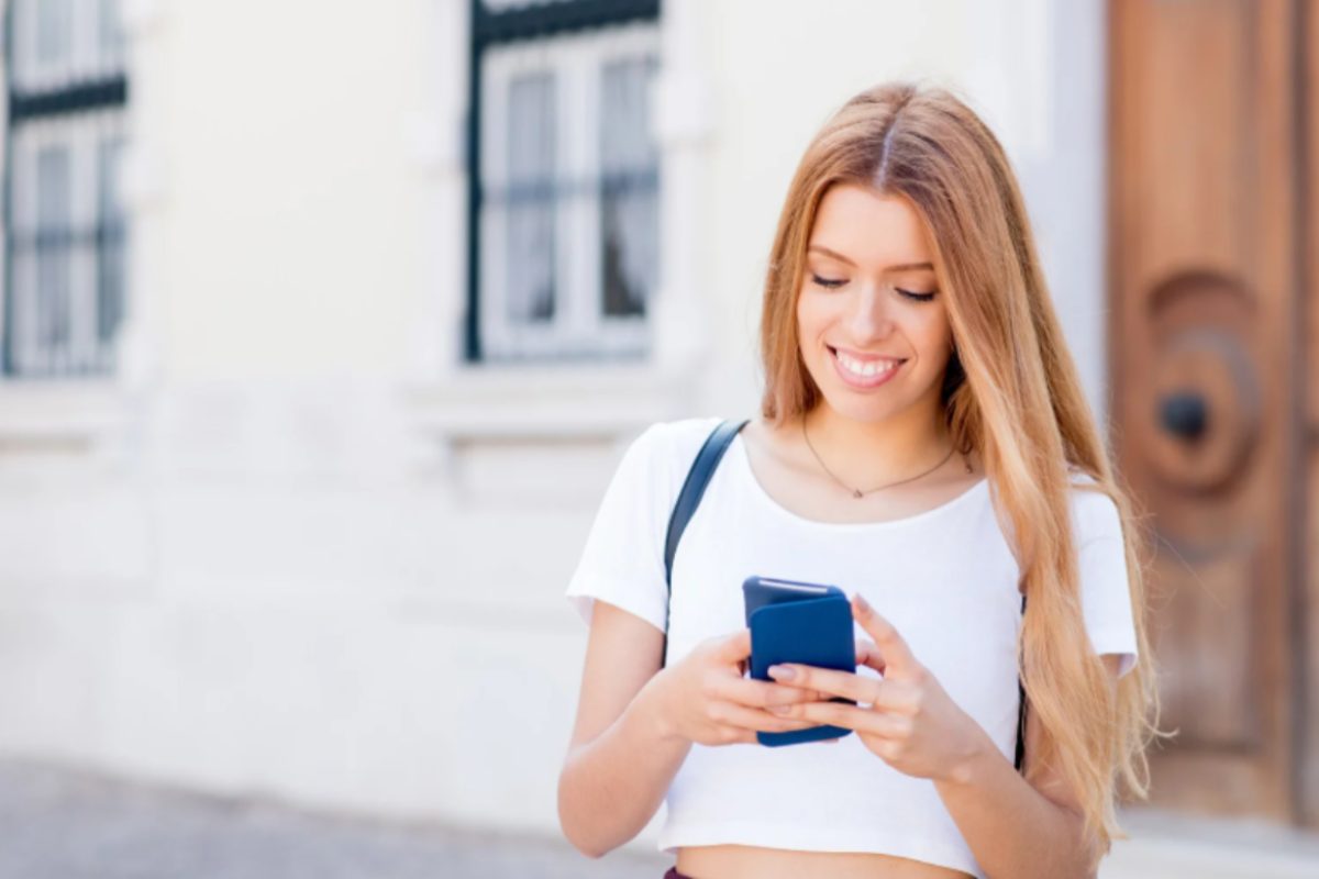 donna sorridente con il cellulare in mano