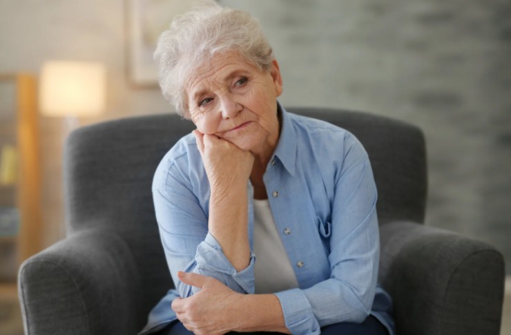 anziana triste seduta in poltrona