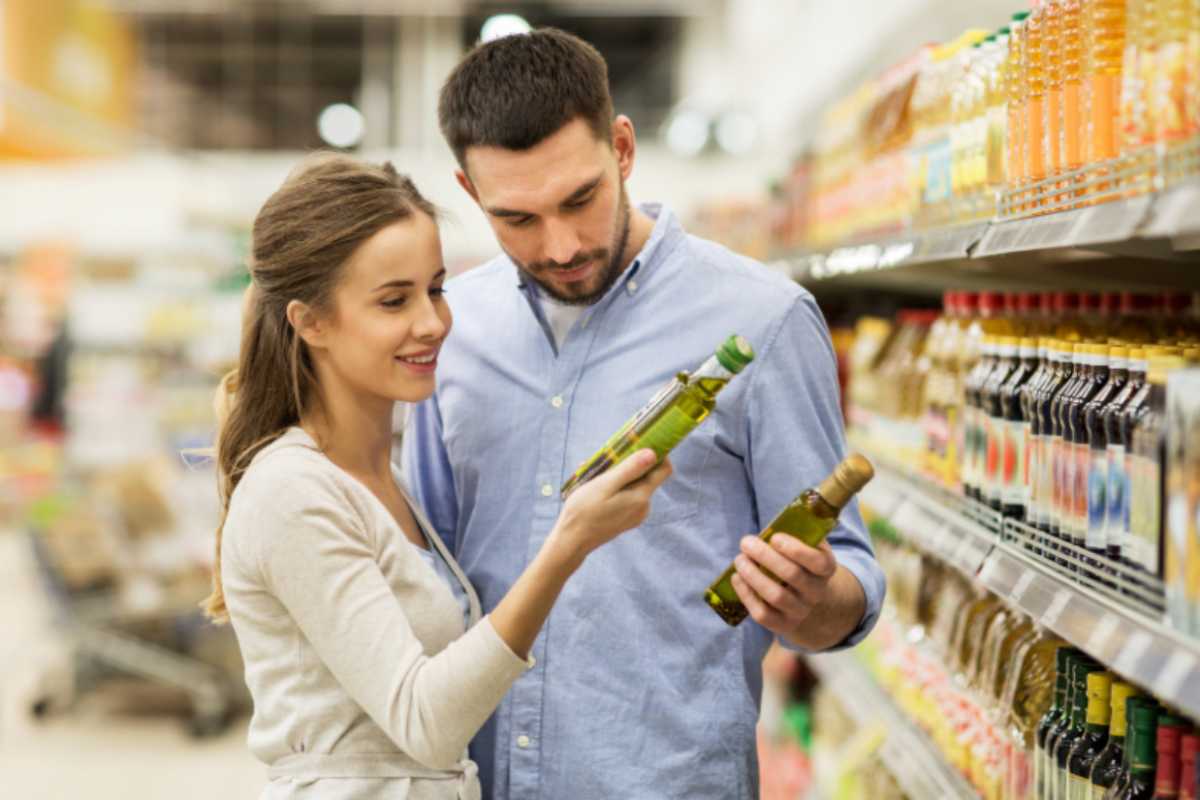 uomo e donna che scelgono l'olio al supermercato