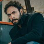 Mimmo accovacciato con il volto serio