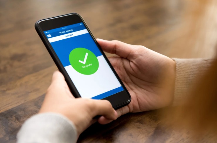 uomo che invia un bonifico attraverso il cellulare