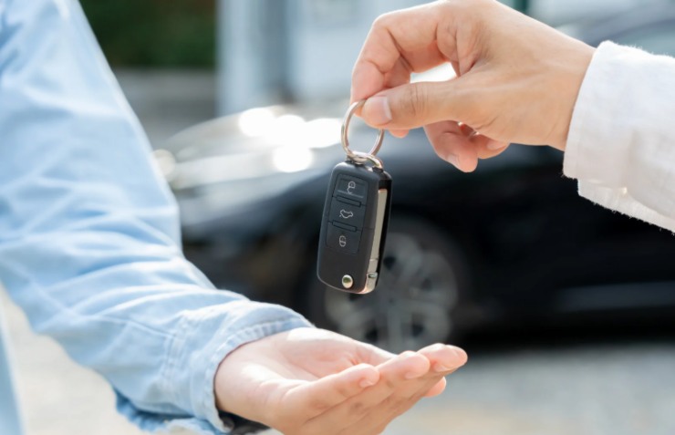 uomo che consegna ad un altro uomo delle chiavi di un'auto