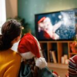 Famiglia con nonna e bambini che guarda film di Natale in TV