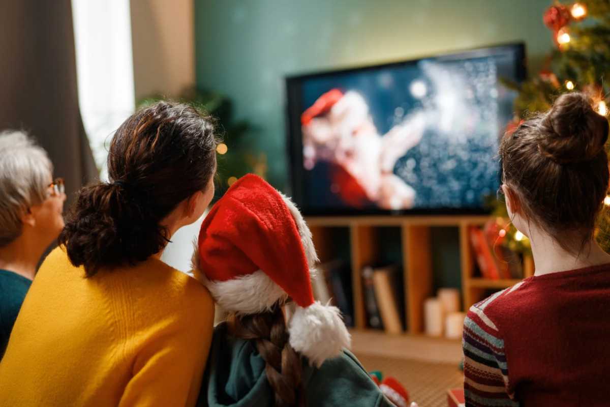 Famiglia con nonna e bambini che guarda film di Natale in TV