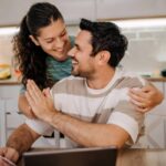 coppia di uomo e donna sorridenti davanti al computer