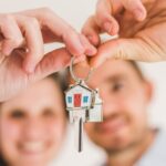 coppia che sorride e tiene in mano le chiavi di casa