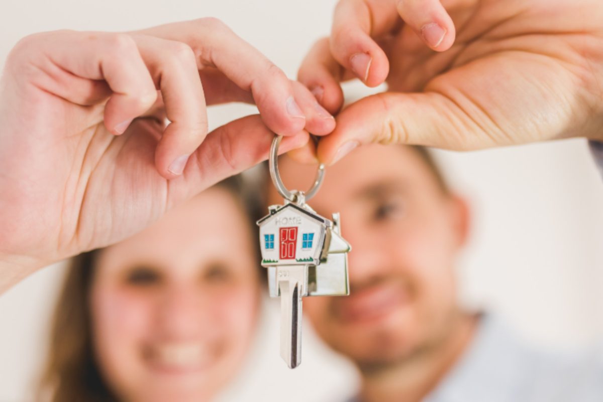 coppia che sorride e tiene in mano le chiavi di casa