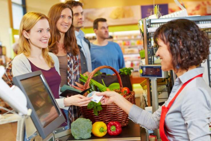 donna che paga alla cassa del supermercato