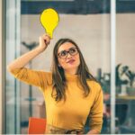 ragazza con il simbolo di una lampadina in mano