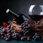 uva nera una bottiglia di vino e un calice di vino rosso