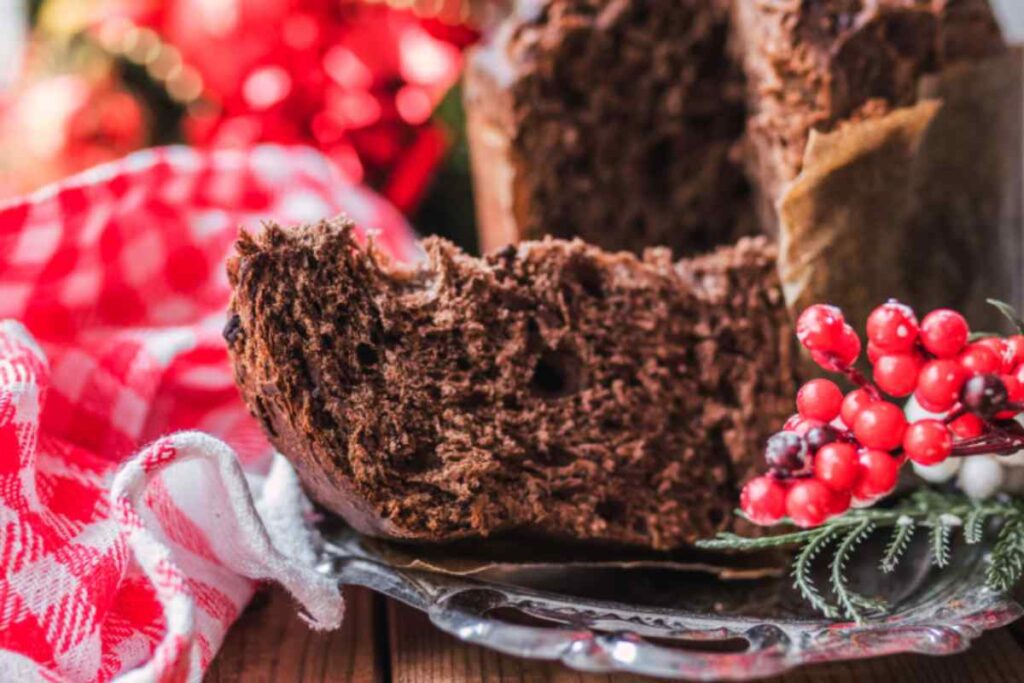 fetta di panettone al cacao con accanto dei ribes rossi