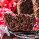 fetta di panettone al cacao con accanto dei ribes rossi