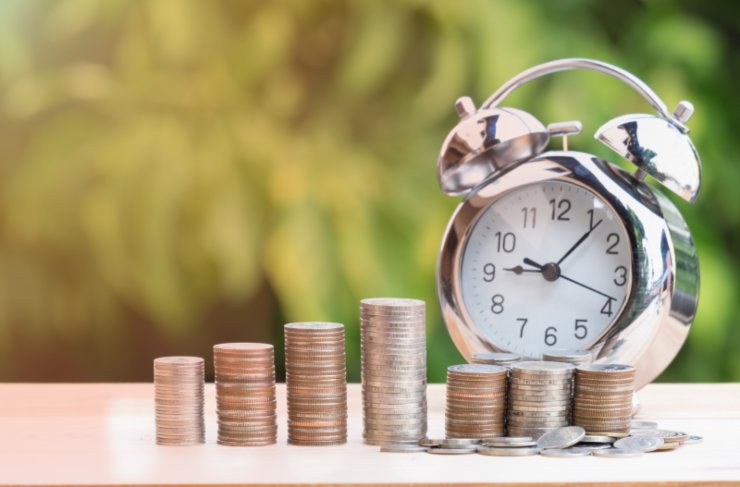 monete di auto e dietro una sveglia