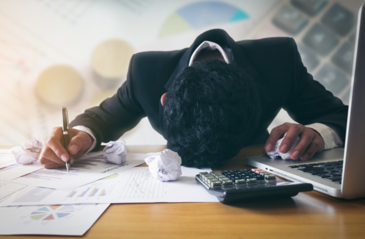 lavoratore con la fronte sbattuta sul tavolo della scrivania 