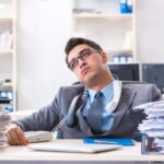 lavoratore che sbuffa seduto alla scrivania in ufficio