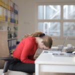 donna con la fronte appoggiata sulla tastiera del computer