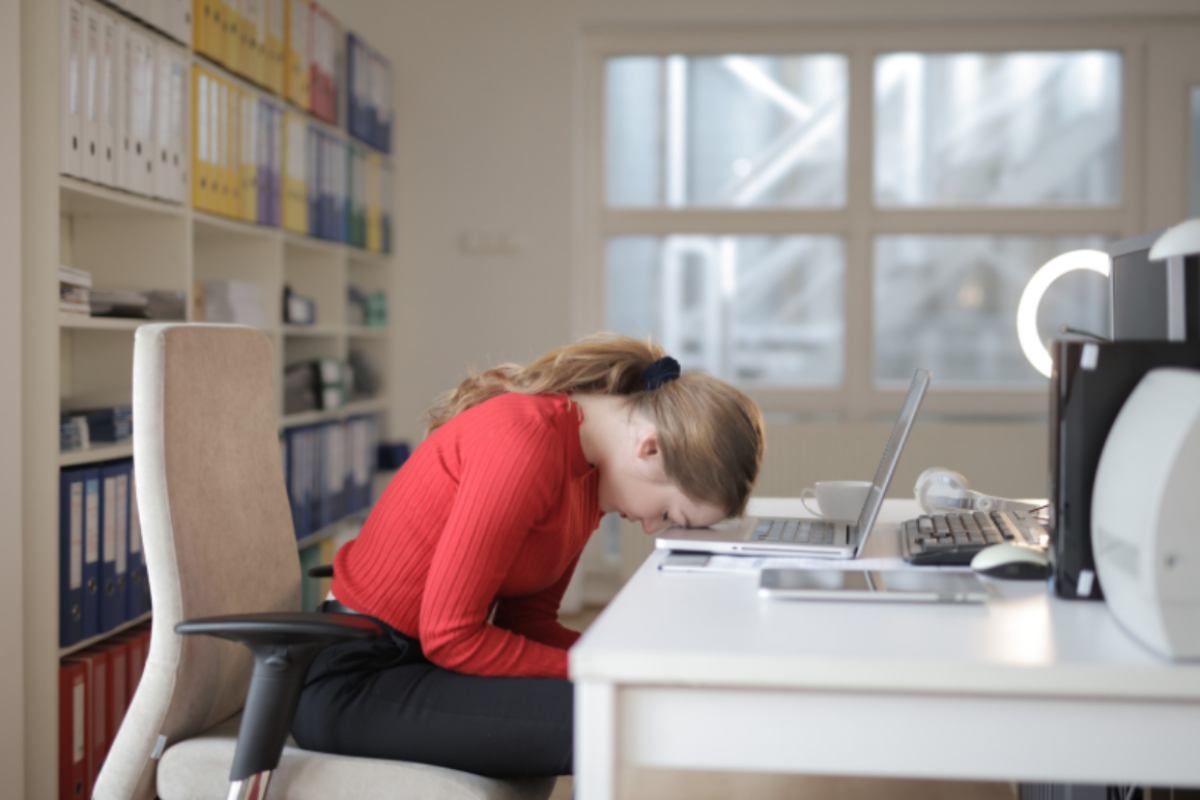 donna con la fronte appoggiata sulla tastiera del computer