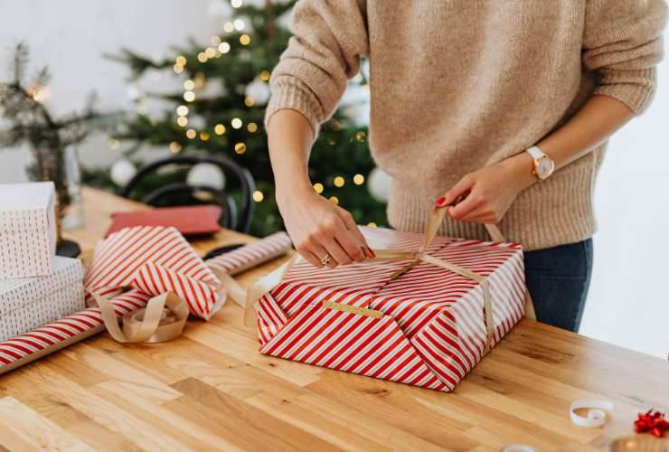 persona che fa un pacchetto regalo