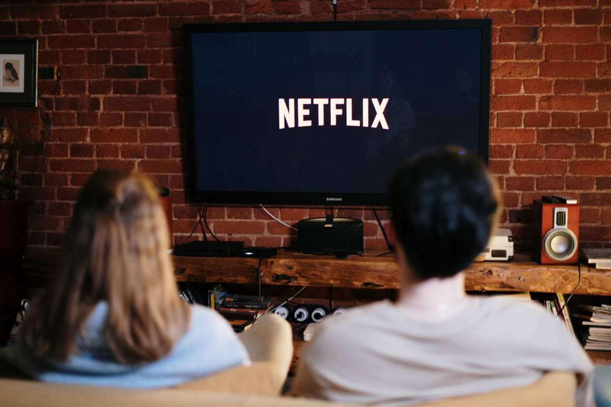 Un uomo e una donna che guardano Netflix sul divano